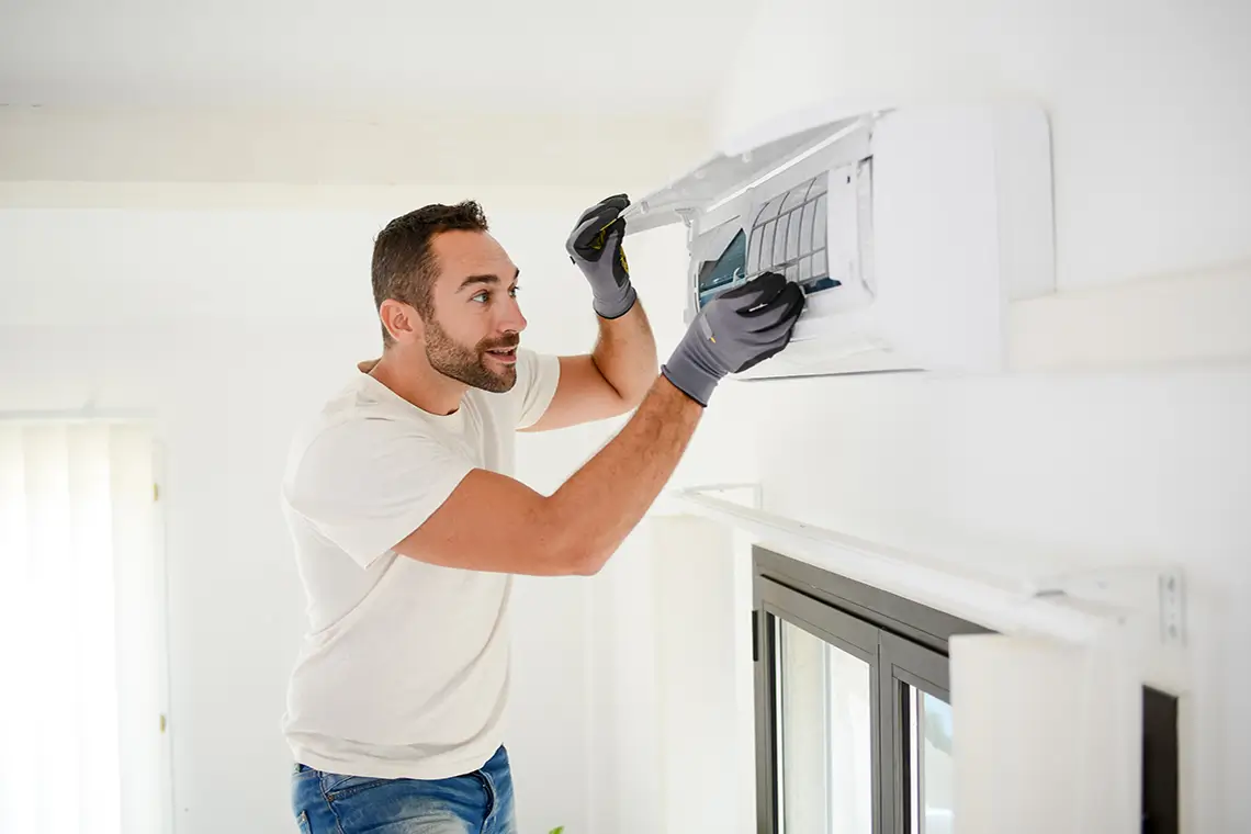 Fachmann reinigt und wartet Klimaanlagenfilter zur Sicherstellung effizienter und sauberer Luft.