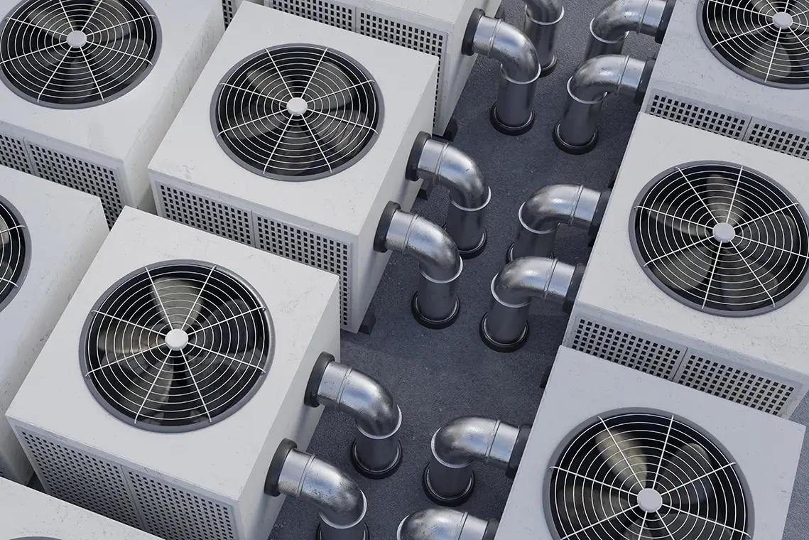 Mehrere große Lüftungs- und Klimageräte mit Rohrleitungen auf einem Flachdach