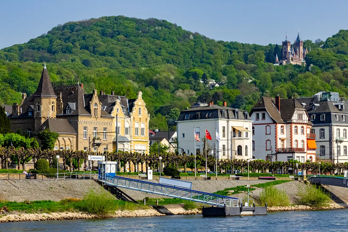 Historische Häuserfronten und Uferpromenade in Königswinter mit Blick auf den Rhein und bewaldete Hügel Historische Häuserfronten und Uferpromenade in Königswinter mit Blick auf den Rhein und bewaldete Hügel
