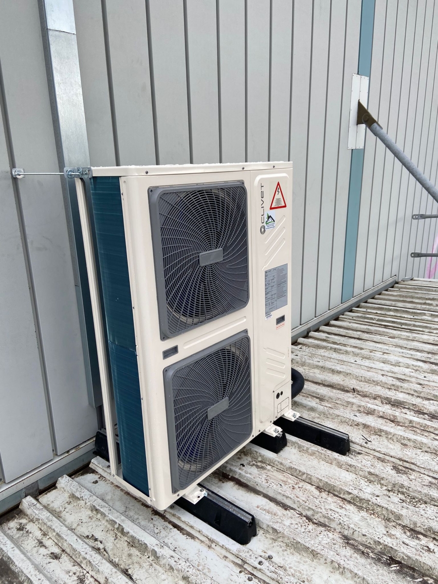 Detailansicht einer fachgerecht montierten Außeneinheit der Klimaanlage auf dem Hallendach der pharmazeutischen Logistikhalle.